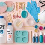 Essential resin art supplies for beginners, including epoxy resin, safety gear, silicone molds, pigments, and finished beginner projects